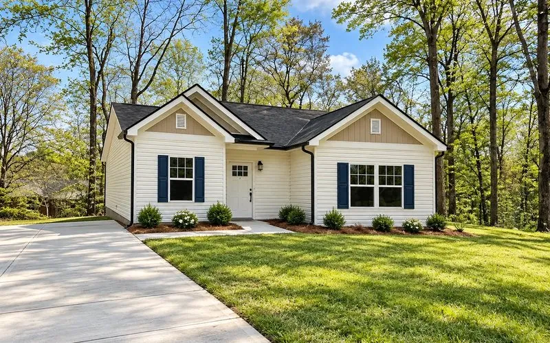 The Kinhill, a single-story cottage with navy shutters and twin front gables