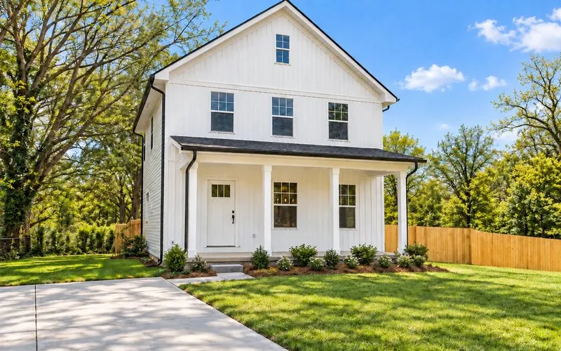 The Rankin, a two-story white board-and-batten farmhouse with a covered front porch